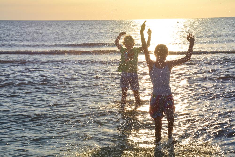 Kinder springen und spielen in der Ostsee